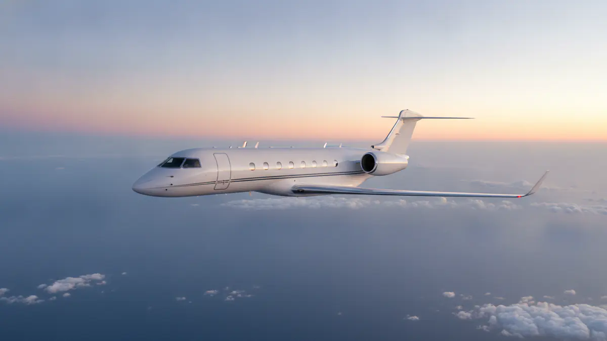 Private jet range: long-range business jet over the ocean at sunrise